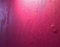Close-up of a textured fuchsia wall with a bright gradient light. Rough plaster surface shows imperfections and shadows. Ideal Royalty Free Stock Photo
