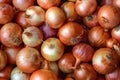 Close up, textured made from pile of fresh onions for sale at a farmers market, top view