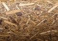 Close-up of a textured surface composed of compressed wood shavings and chips. The material varies Royalty Free Stock Photo