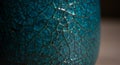 A close-up of a textured surface with a cracked pattern, displaying a vibrant turquoise Royalty Free Stock Photo