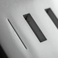 Close-up of a textured surface with rectangular apertures, resembling metallic slots Royalty Free Stock Photo