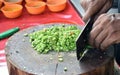 Chaf slicing Chili pepper with Knife on wooden board