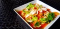 Close up Thai spicy seafood salad with glass noodle, squid, shrimp, sliced tomato, onion, carrot and celery on white dish or plate Royalty Free Stock Photo