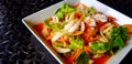 Close up Thai spicy seafood salad with glass noodle, squid, shrimp, sliced tomato, onion, carrot and celery on white dish or plate Royalty Free Stock Photo