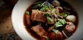 Close up Thai style noodle with slices of beef, pork ball and top with coriander in soup on white bowl Royalty Free Stock Photo