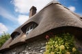 close-up of thatched roof detail over stone chimney of a cottage Royalty Free Stock Photo