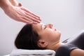 Therapist Giving Reiki Healing Treatment To Woman