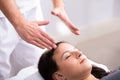 Therapist Giving Reiki Healing Treatment To Woman