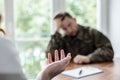 Close-up on therapist hand while helping depressed soldier during treatment