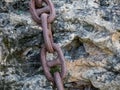 Close up Thick Rusty Chain Background Image. Old rusty metal chain on stone surface Royalty Free Stock Photo