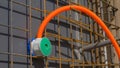 CLOSE UP: Thin corrugated orange conduit runs out of an electricity outlet.