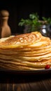 Close up of thin pancakes stacked on a rustic wooden plate