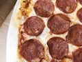 Close-up thinly sliced pepperoni on fresh Italian classic original Pizza. Royalty Free Stock Photo