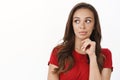 Close-up thoughtful attractive feminine brunette female in red t-shirt touch chin, look left curious, pondering