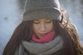 Close-up of thoughtful beautiful Caucasian woman looking down. Portrait of brunette girl in grey hat and scarf at the Royalty Free Stock Photo