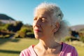 Close-up of thoughtful caucasian senior woman looking away against clear blue sky in yard Royalty Free Stock Photo