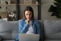 Close up thoughtful focused woman looking at laptop screen