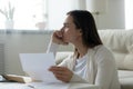 Close up thoughtful frustrated young woman holding paper letter