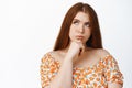 Close up of thoughtful teenage redhead girl looking away, thinking with serious face expression, white background Royalty Free Stock Photo