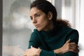 Close up thoughtful upset woman looking in rainy window alone Royalty Free Stock Photo