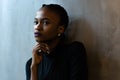 Close-up of thoughtful young black woman looking away with hand under the chin, gray background Royalty Free Stock Photo