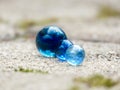 Close up of three blue glass marbles in a lined up together with blurred background space to place text Royalty Free Stock Photo