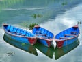 Close up of three bright blue boats, calm Fewa lake, Pokhara, Nepal