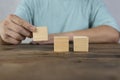 Close-up of three businessmen arranging wooden blocks Wooden toy blocks on a desk can be inserted with image text Royalty Free Stock Photo