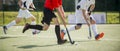 Close up of three field hockey players, challenging eachother for the control and posession of the ball during an intense, competi Royalty Free Stock Photo