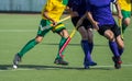 Close up of three field hockey players, challenging eachother for the control and posession of the ball during an intense, competi Royalty Free Stock Photo