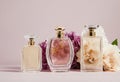 Close up of three glass perfume bottles with flowers on beige background. Selective women's toilet water. Copy space Royalty Free Stock Photo