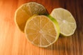 close up of three halves of lemons or limes on bamboo cutting board