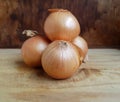 three onions arranged on a chopping board Royalty Free Stock Photo