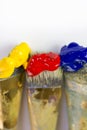 Macro three paint brushes with red, yellow and blue paint on a white background. Place for text, for banner, for site. Royalty Free Stock Photo