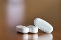 Close -up of three pills with oval shape on a table, selective focus Royalty Free Stock Photo