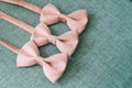 Three pink bow ties on green textural background, men and gentleman accessories