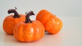 Close-up of three plastic orange pumpkins on a white background, copy space. Decor concept Happy Halloween holiday. Thanksgiving Royalty Free Stock Photo