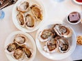 Close up of three plates of fresh oysters and red bean cake and apple cake on the white table, hotel buffet Royalty Free Stock Photo