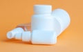 Close-up of three portable plastic bottles with tablets and vitamins and one transparent plastic bottle with a disinfectant