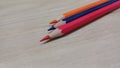 Close up of three sharp colored pencils lying diagonally on a light wooden texture background with copy space Royalty Free Stock Photo