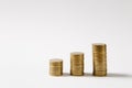 Close up three stacks of golden coins of different heights in a row isolated on white background. Concept of money Royalty Free Stock Photo