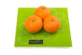 Three sweet mandarin on scales Royalty Free Stock Photo