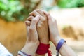 Close up of three women hands up in the air hands holding tight each other as a symbol of feminism and feminine friendship with