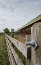 Close-up of a timber-framed farm gate with a distant view of a small dairy herd.