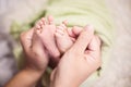 Close-up tiny baby feet in hands. Mother care of newborn baby. Royalty Free Stock Photo