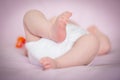 A close-up of tiny baby or infant feet and red pacifier on the blur background