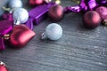 Close up of tiny silver sparkling Christmas ball. New year toys, hearts and balls on wooden grey surface. Flat layer