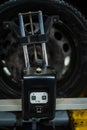 Close-up of a tire clamped by a leveler that passes the automatic alignment of the wheels in the garage, garage and