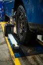 Close-up of a tire clamped by a leveler that passes the automatic alignment of the wheels in the garage, garage and