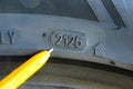 Close-up of tire sidewall showing DOT code 2125 production week and year marking with pen pointer Royalty Free Stock Photo